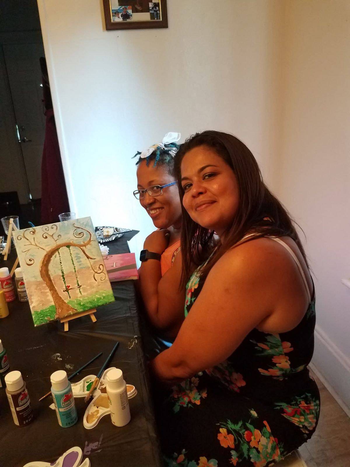 Two friends posing with their painting
