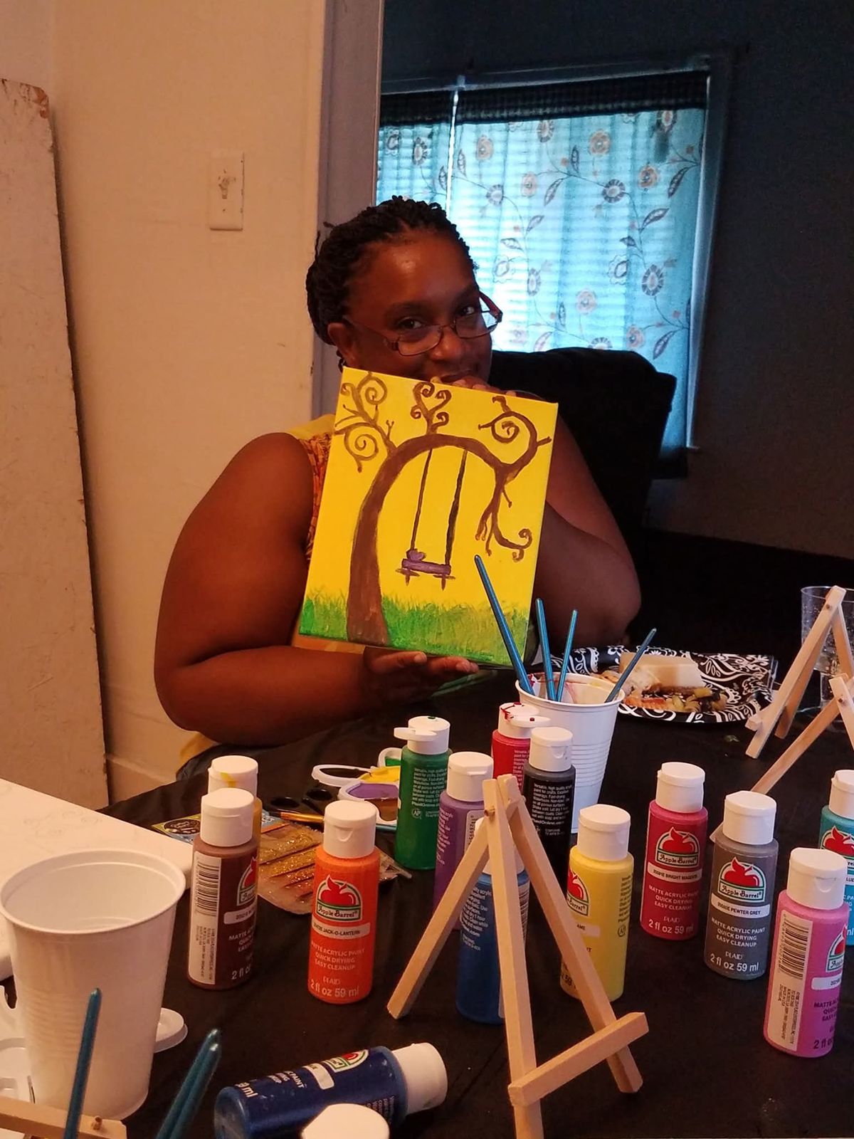 A member holding up her colorful canvas