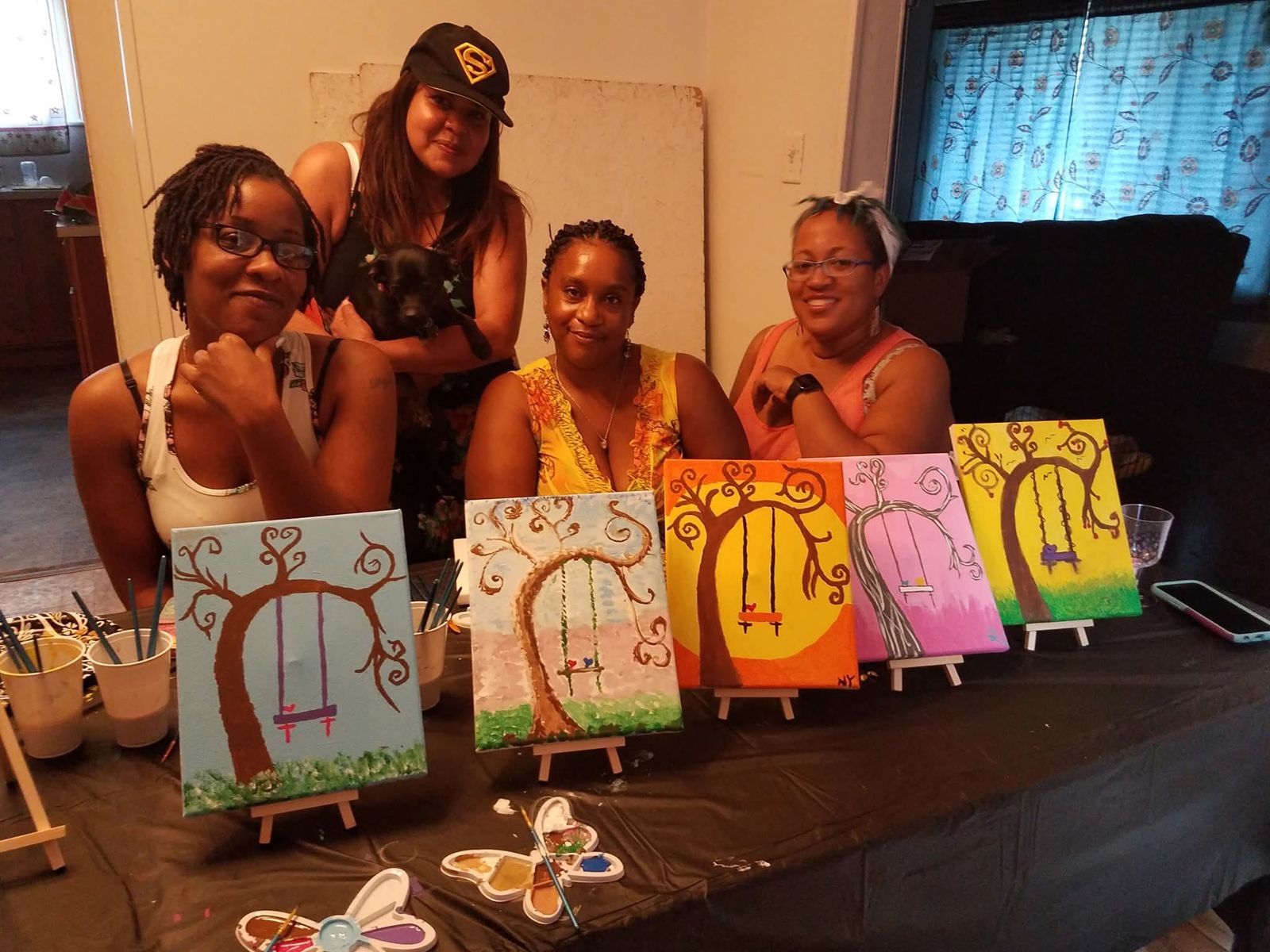 SHH women holding their finished canvases at paint night